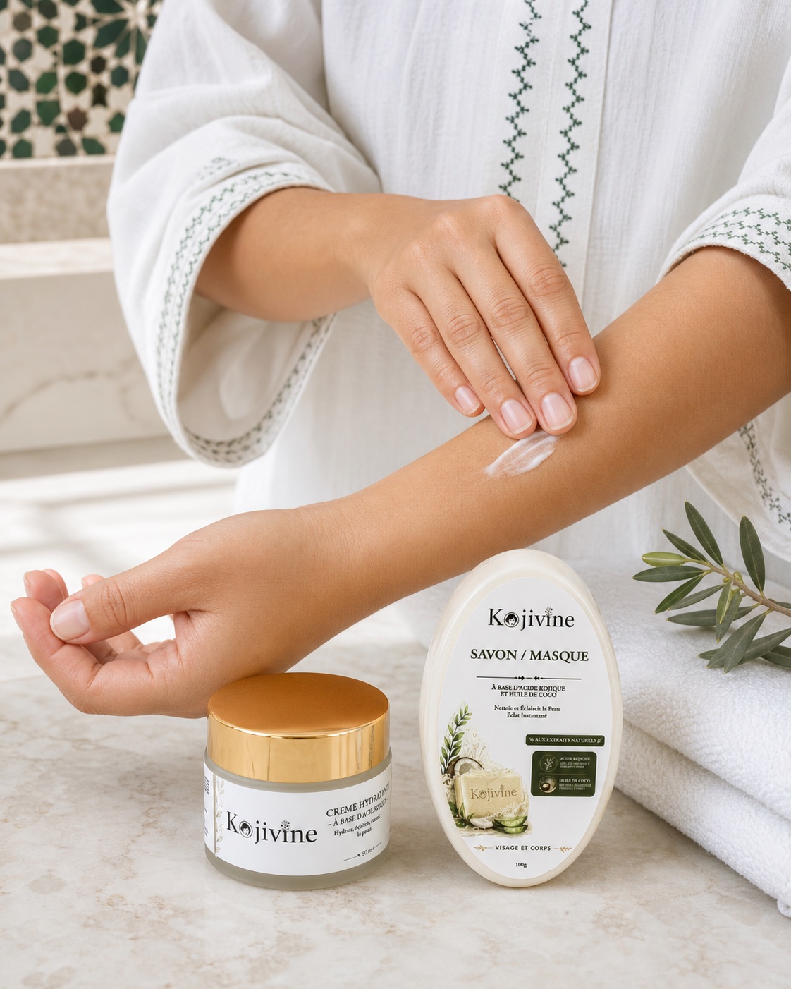 Application de la crème Kojivine sur l’avant-bras avec le savon masque et la crème entièrement visibles